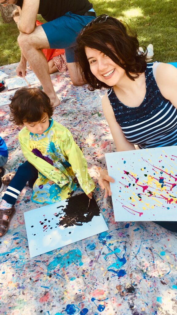 happy young mother painting with her cute son sitting at Jackson Pollock’s home