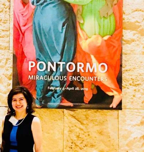 woman smiling in front of a painting